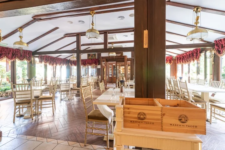 Zona de vinărie a restaurantului Casa del Sole, cu sticle expuse și pahare lustruite